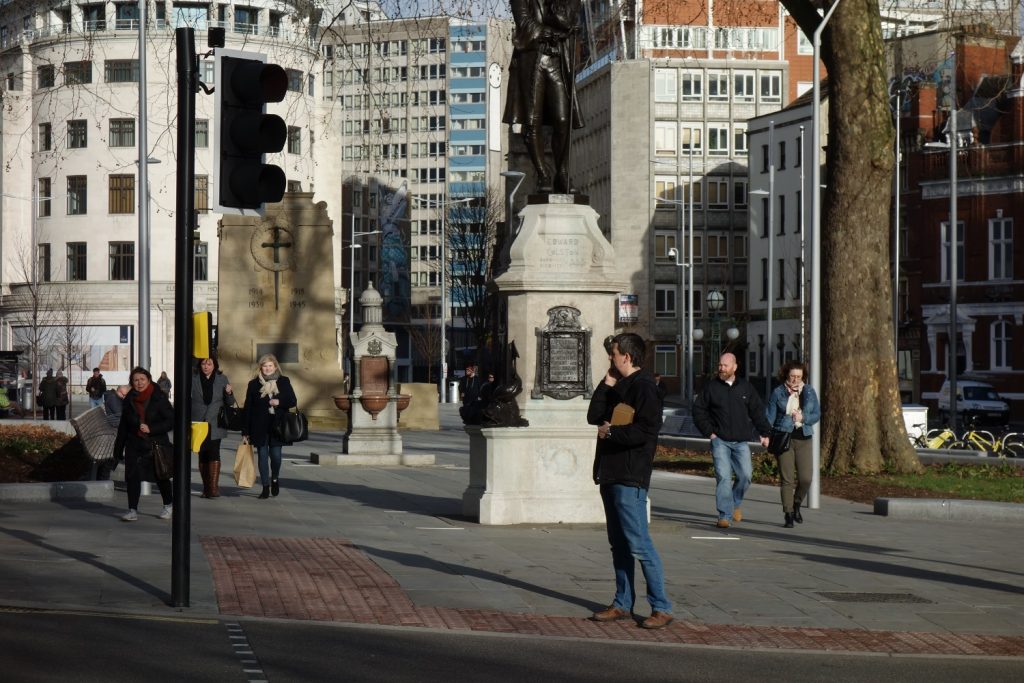 Bristol city centre after metrobus construction work - people walking and standing near statue