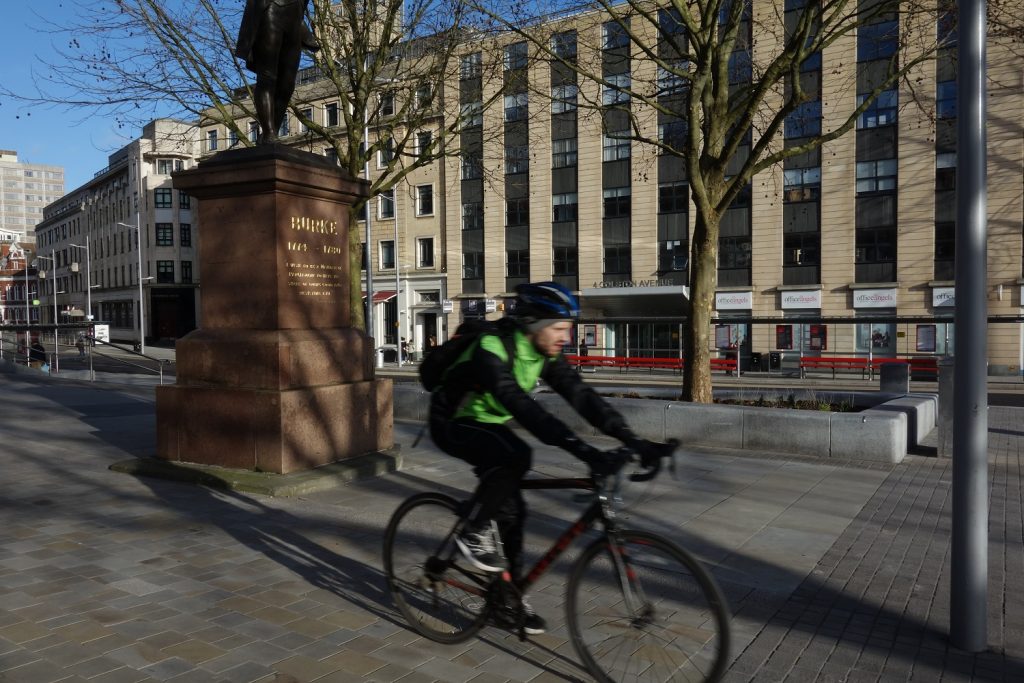 Bristol city centre after metrobus construction work - cyclist passing near statue