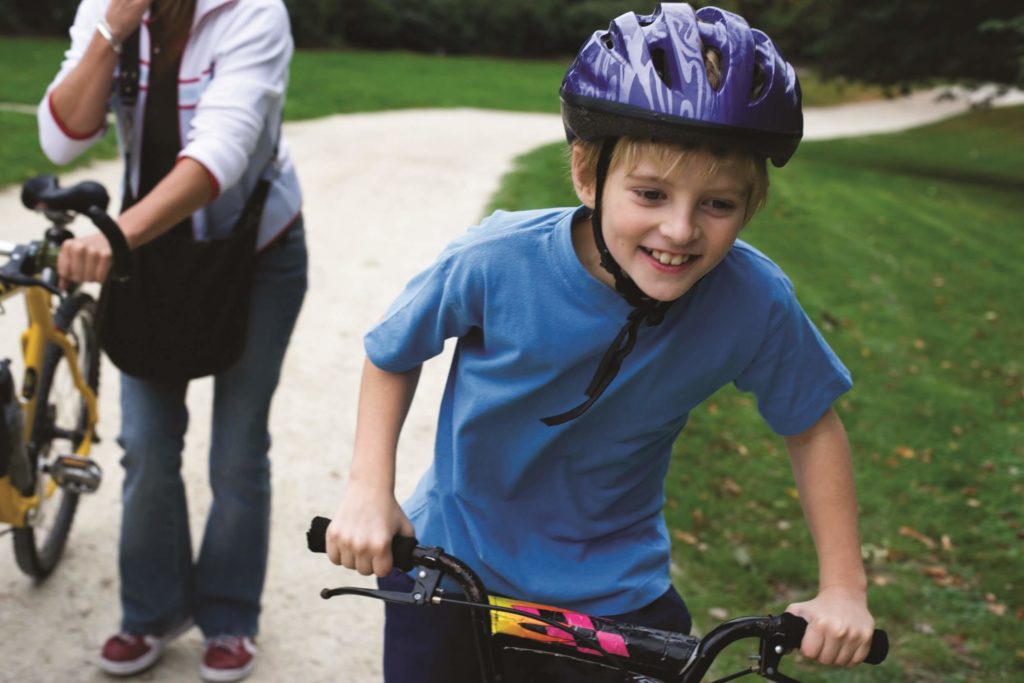 Young boy riding a bike on a park path