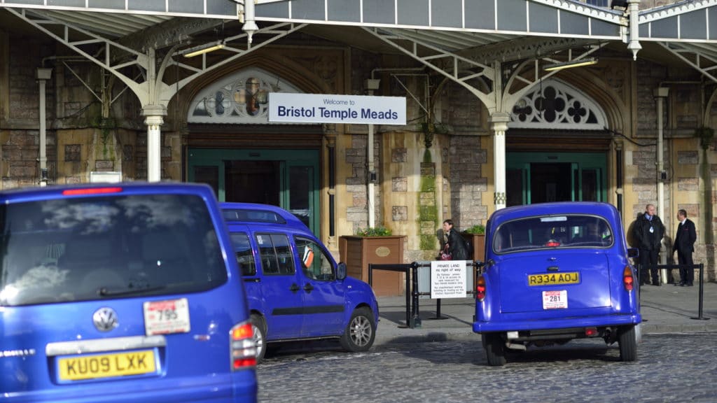 Bristol blue taxis queued up outside of Bristol Temple Meads main entrance.
