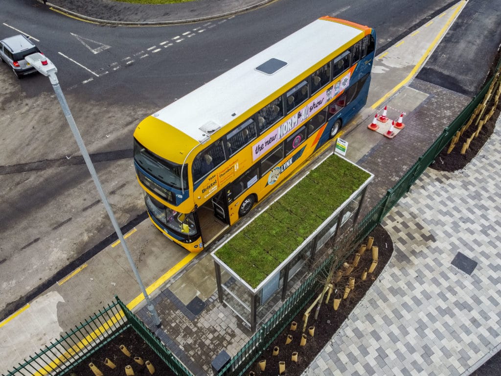 Aerial photo of bus at bus stop with a living roof.