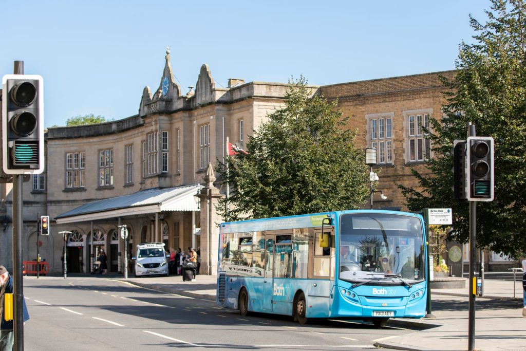 Bath Spa railway station entrance with buses passing by
