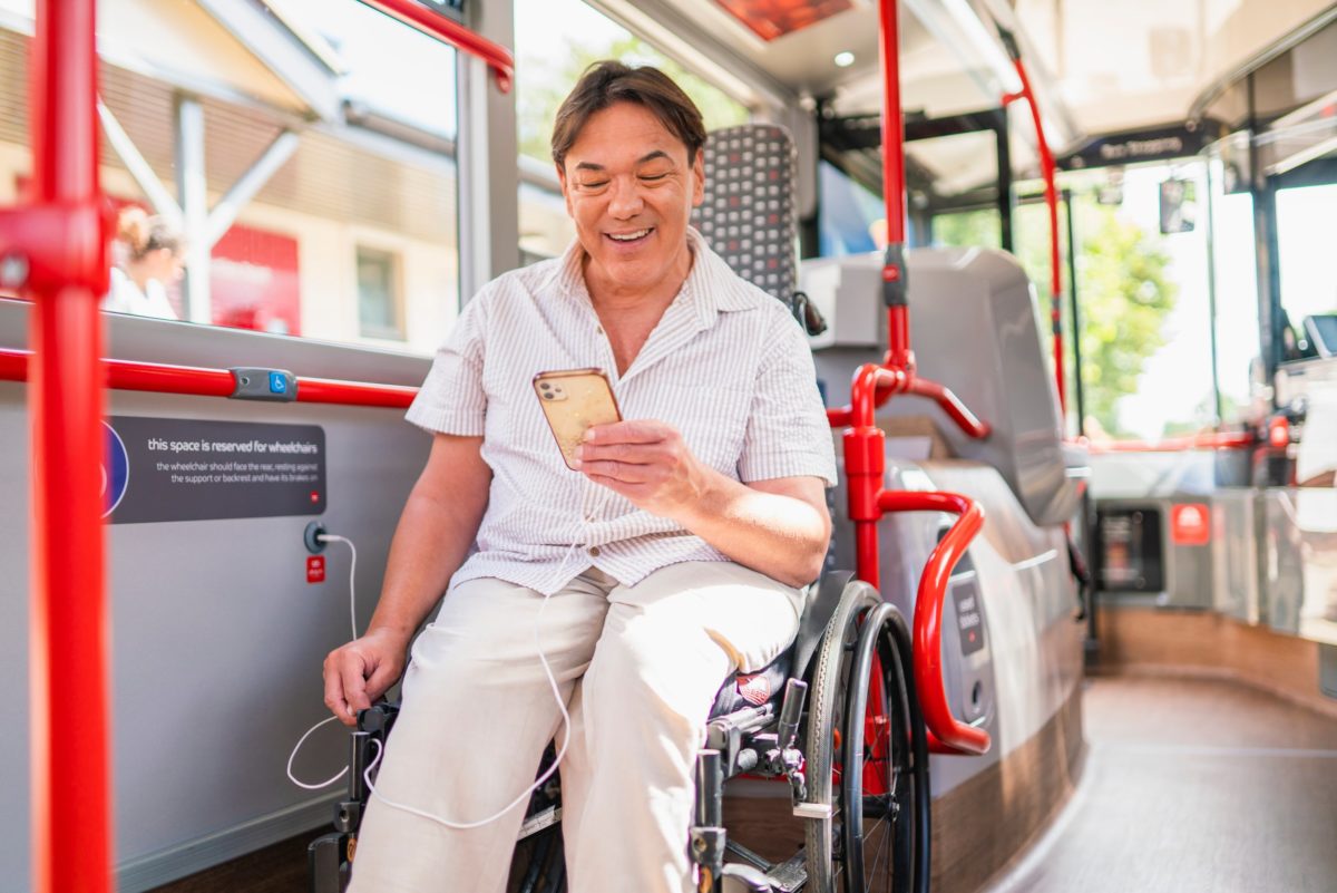 Disabled-person-in-wheelchair-looking-at-their-mobile-phone-on-board-a-bus-1200x801.jpg