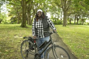 Copyright BCC - Smiling person standing next to a REVOS e-bike