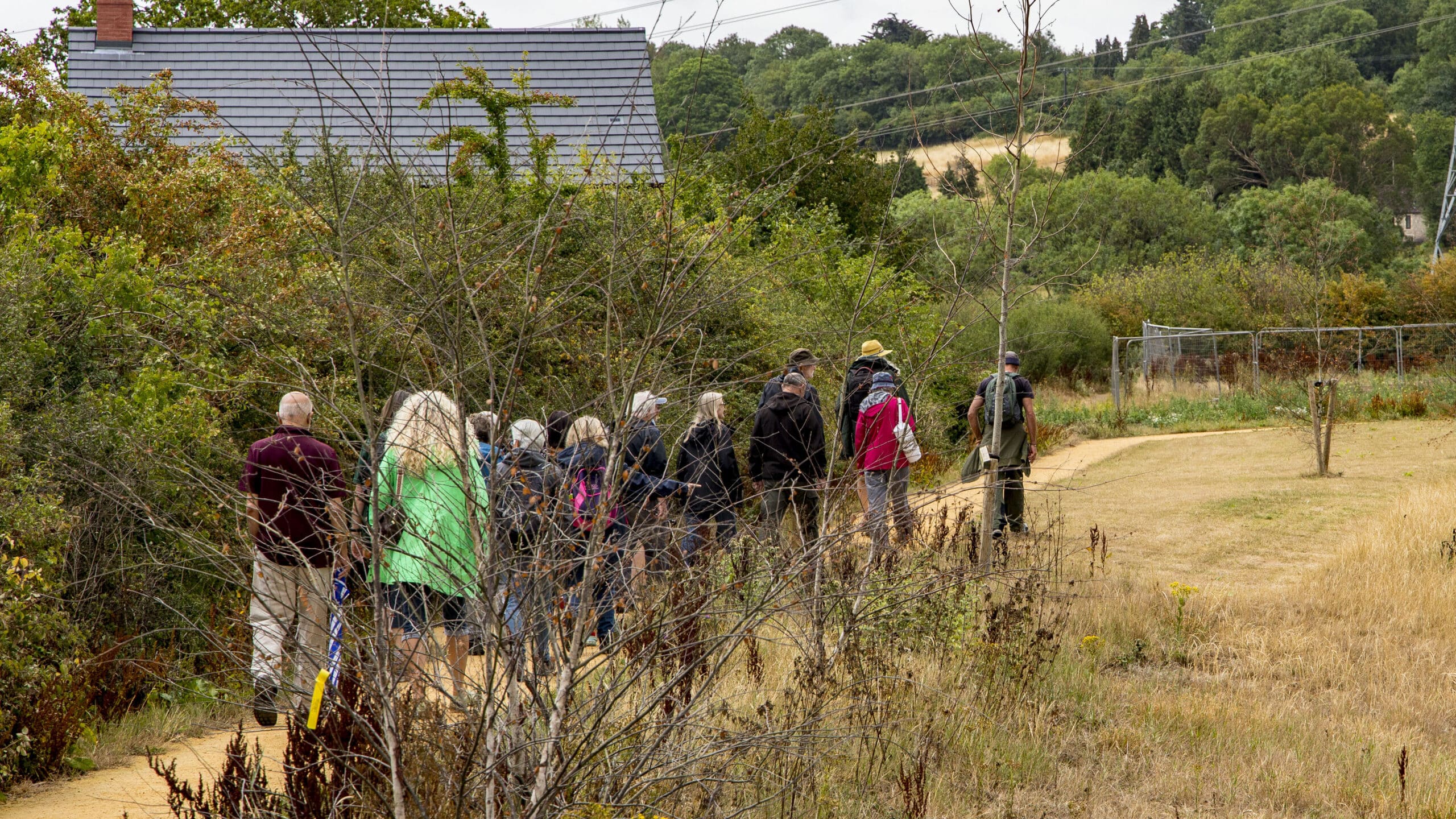 Photo of a group of people setting off on the walk being led by the walk leader.