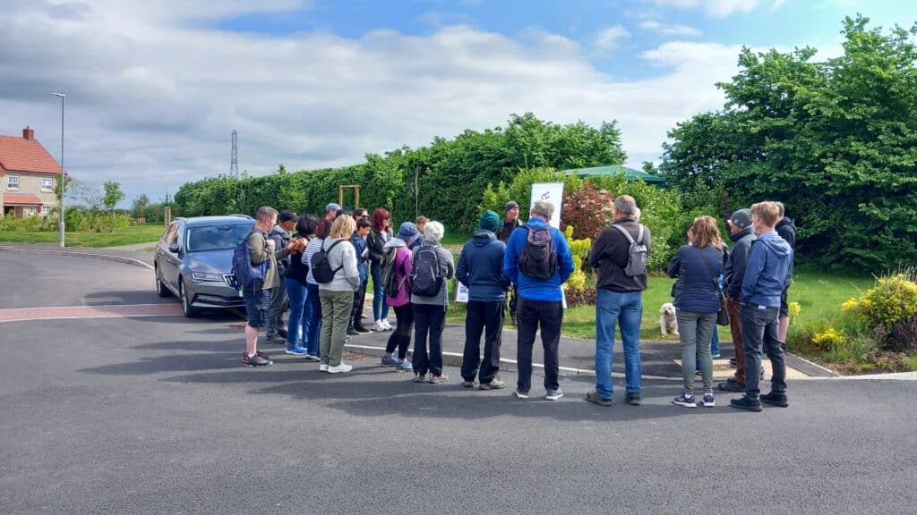 Photo of a group of people gathered around the walk leader at the start of the walk.